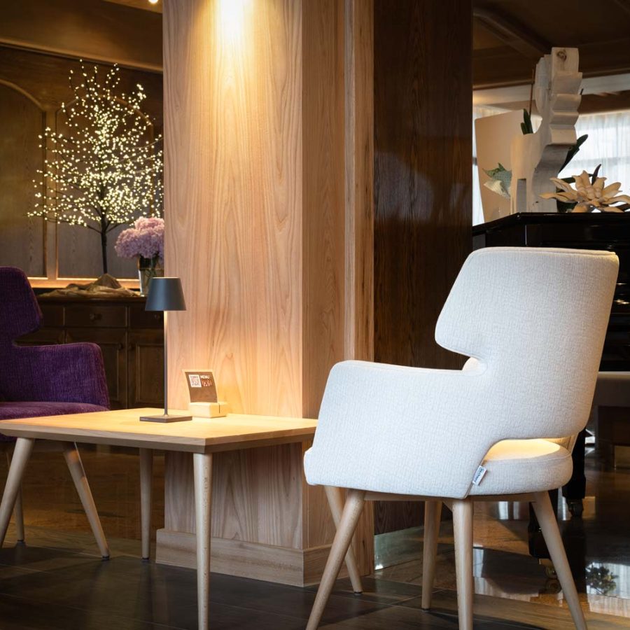 Hotel-Isolabella-wellness-art-&-music-fiera-di-primiero-trento-pianoforte-nella-sala-relax-con-arredamento-moderno-di-bs-chairs