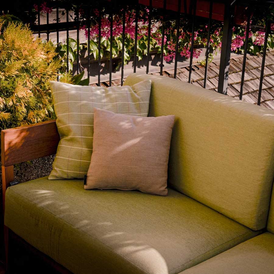 Atmosfera naturale: Divano Rio de Janeiro e tavolini in legno di iroko a Dimaro.