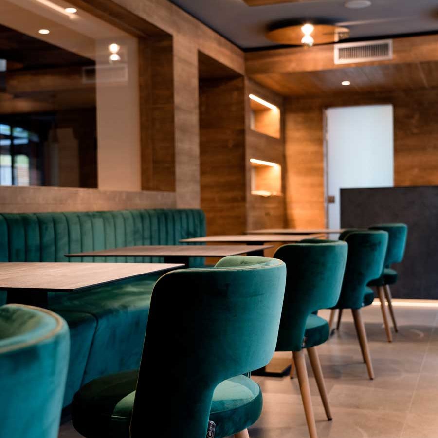 Dettaglio dell'arredamento dell'Hotel Ariston: Panche con cuciture verticali e zoccolo in legno per un design pratico ed elegante