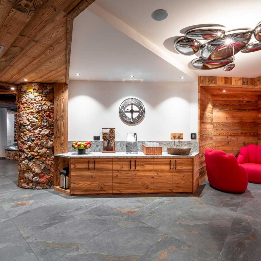 hotel-croce-bianca-canazei-sala-colazione-in-legno-con-poltrone-rosse