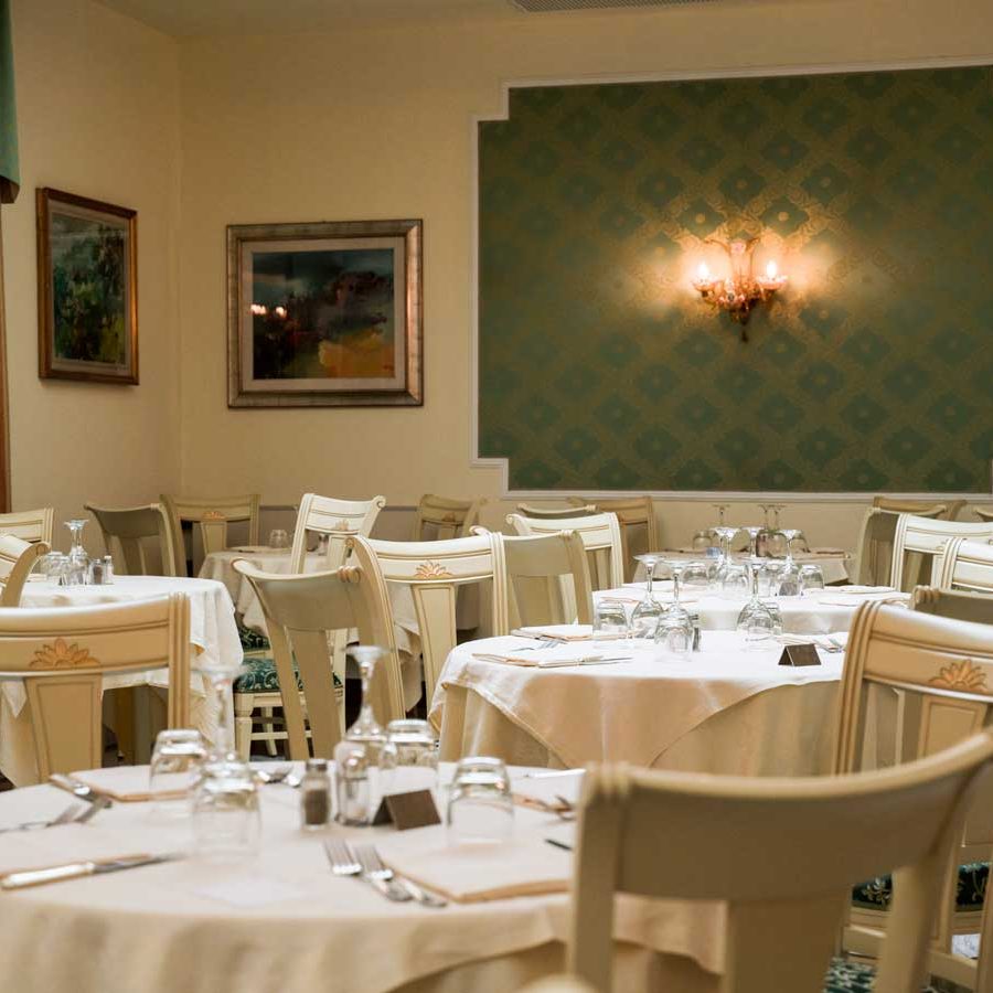 Charme senza tempo: Il modello laccato bianco patinato con dettagli decorati in oro dona un'eleganza senza tempo alla sala ristorante.