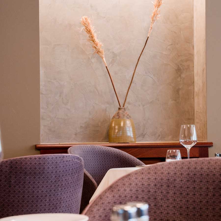 Sedie e poltrone in velluto bianco, parte di un arredo elegante e rispettoso, nell’ambiente silenzioso dell’Hotel Villa Nicolli.