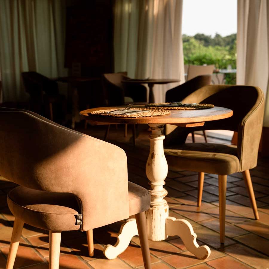 Eleganza al Relais Rossar: Un tavolo e sedie raffinate immerse in un’atmosfera tranquilla