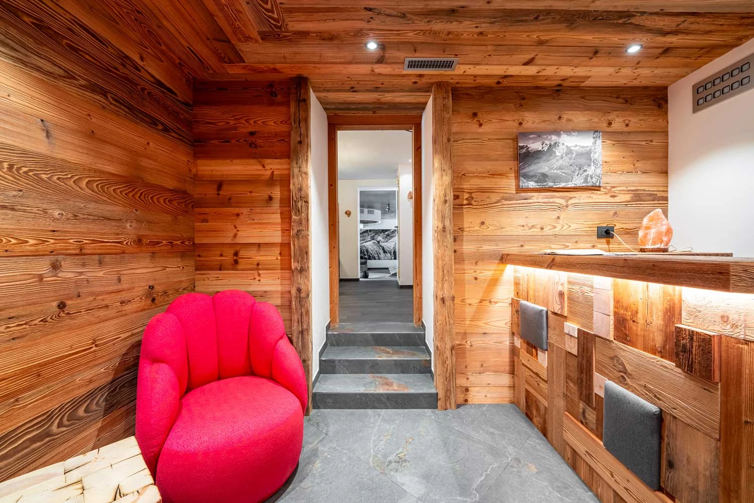 Ingresso spa hotel croce bianca canazei con struttura in legno e poltrona rossa — interior design
