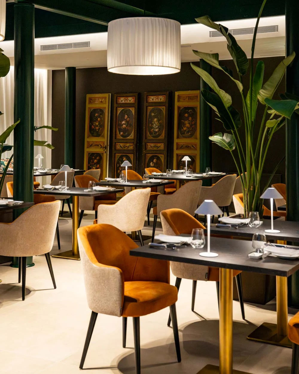 Restaurant with plants and orange chairs at the Hotel Posta Donini in Perugia — interior design